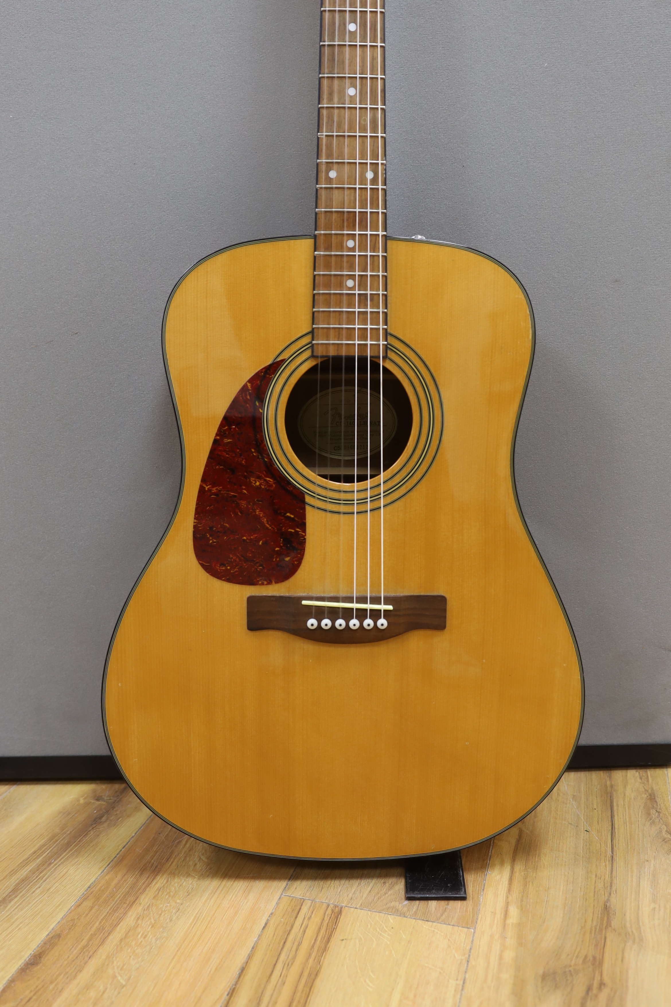 A Fender acoustic left handed guitar, in a hard case